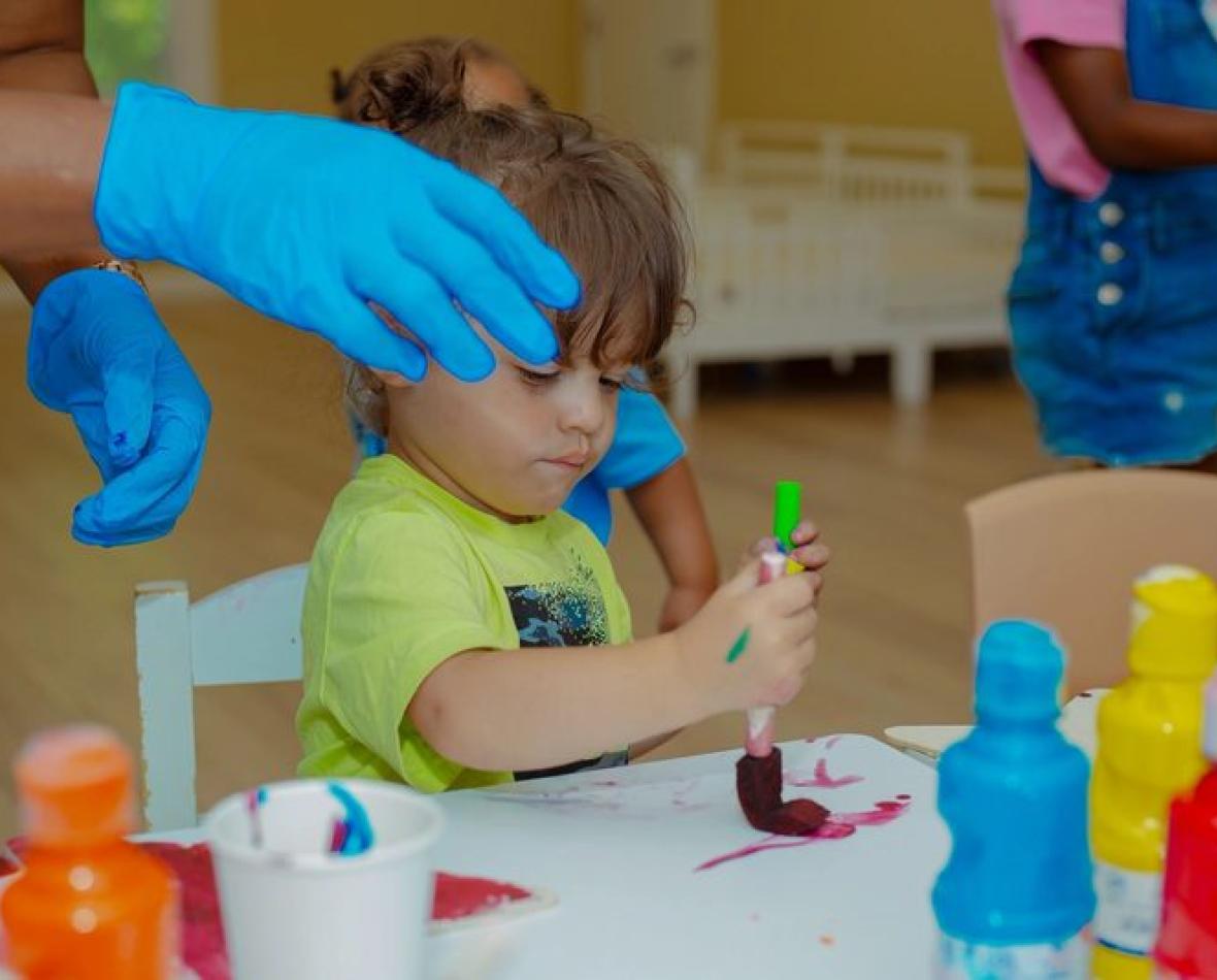 A child mixing paints during a hands-on art session