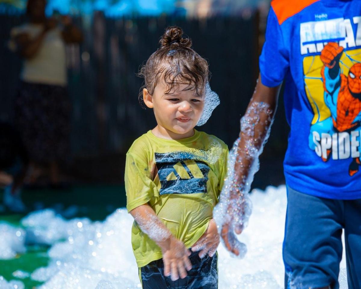 Children laughing together during outdoor foam play